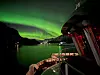 5. PLASS til Kjell Rune Gausvik: Bildet utmerker seg med sterke kontraster mellom det grønne nordlyset og det røde lyset om bord. FOTO: Kjell Rune Gausvik