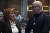To personer snakker sammen under et landsmøte i en konferansesal.