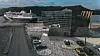 Et passasjerskip seiler forbi et moderne glassbygg ved havnen i Fosnavåg.